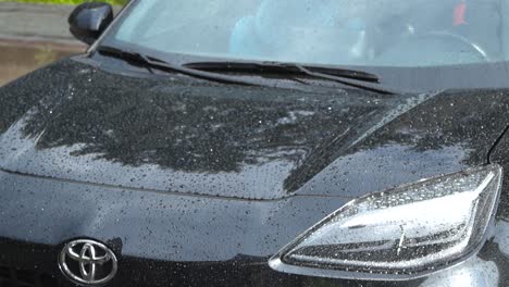 close-up of a black toyota car covered in raindrops