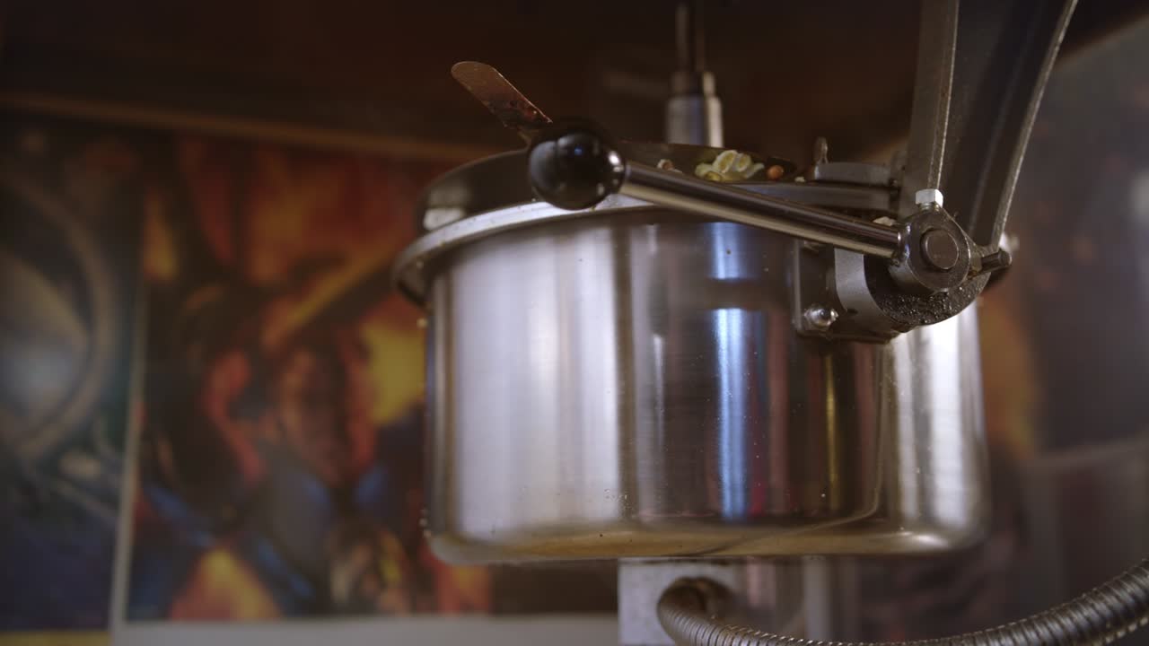 Popcorn pour out of popcorn machine. Worker control popcorn production process