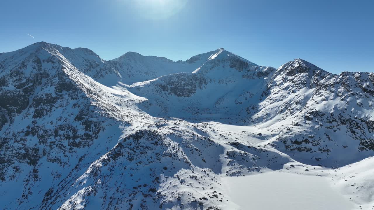 Jepretan drone, keindahan Gunung Rila di Bulgaria, Puncak Musala di kejauhan, musim dingin, langit biru cerah