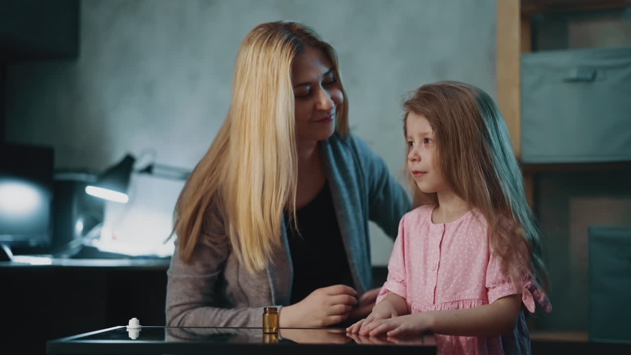 Vrouw geeft pil aan dochter om pijn te verlichten in halfdonkere kamer