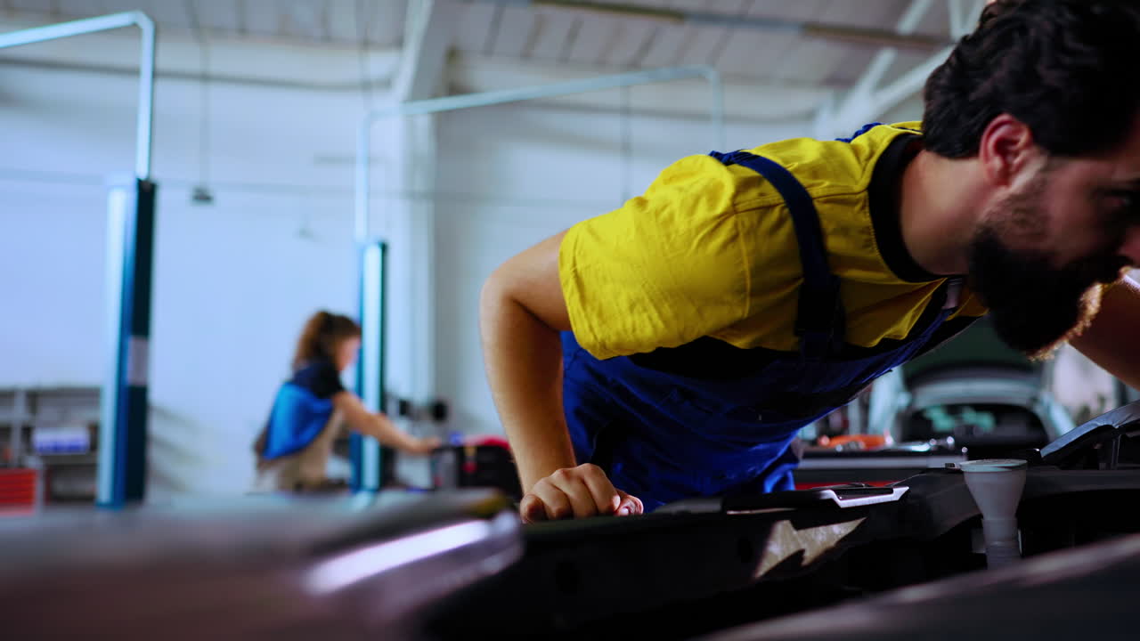 el empleado utiliza la luz para comprobar el coche.