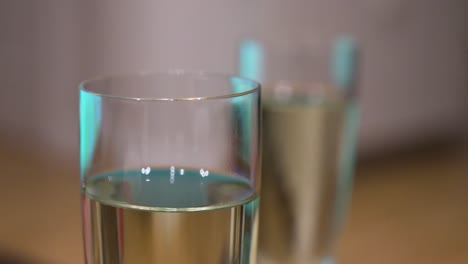 una vista de primer plano y enfoque estrecho de una bebida de champán y vasos de pie en una tableta