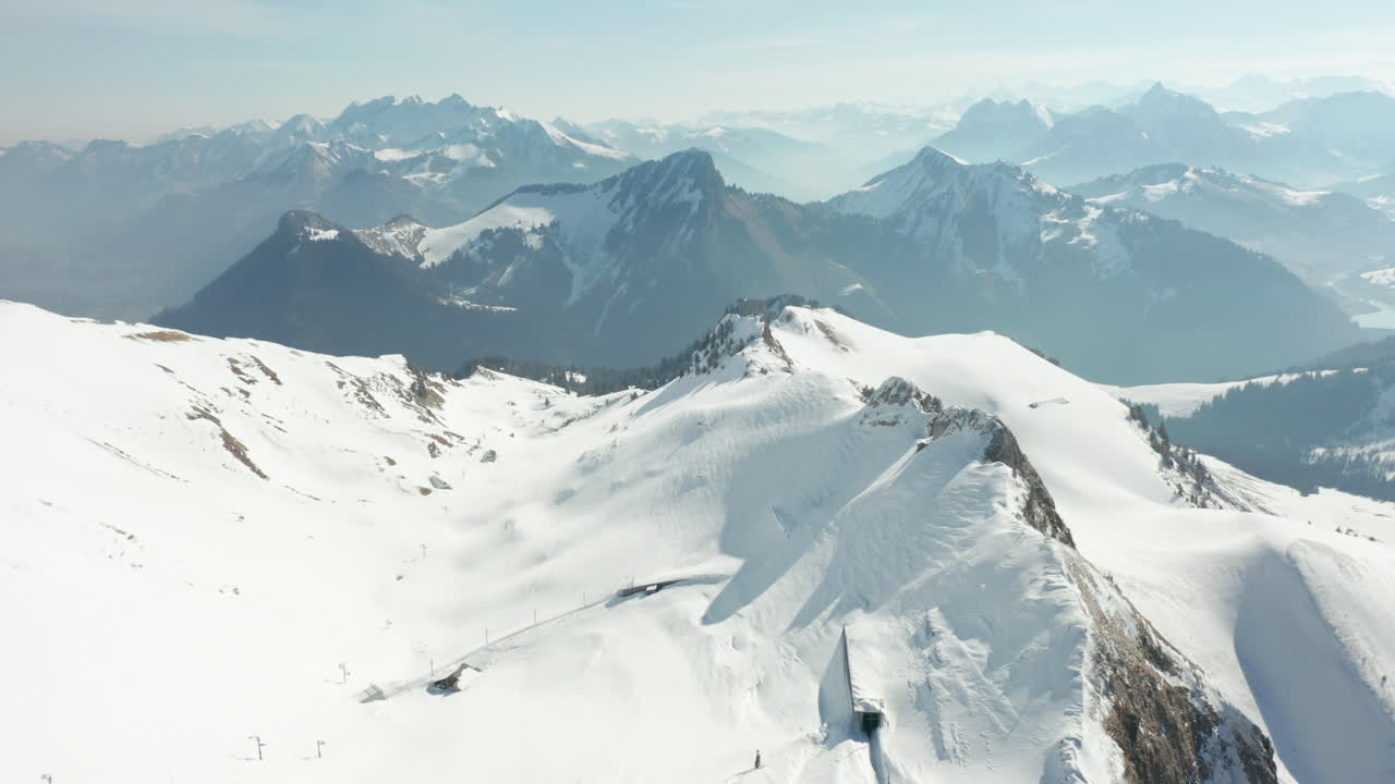 inclinación aérea de la hermosa cumbre de la montaña cubierta de nieve y que revela una vista impresionante de los alpes suizos