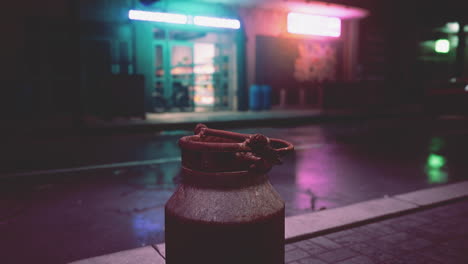 rusty milk can on a dark city street at night