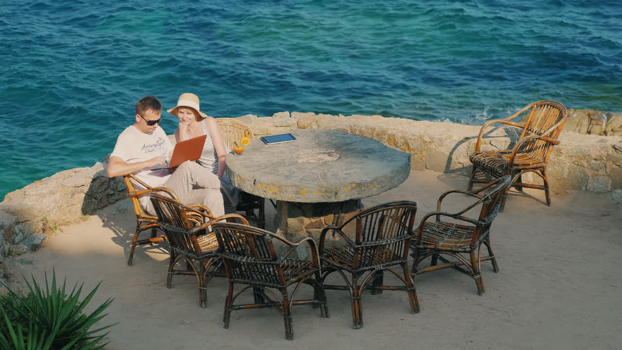 노트북 여자와 함께 일하는 리조트 남자의 부부는 근처에 앉아