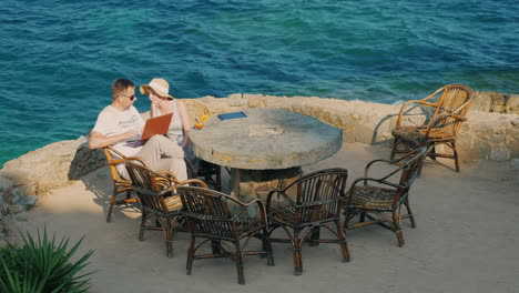 Das-Paar-Im-Resort-Mann,-Der-Mit-Einer-Laptop-Frau-Arbeitet,-Sitzt-In-Der-Nähe