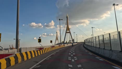 vehicle crossing a cable-stayed bridge at sunset