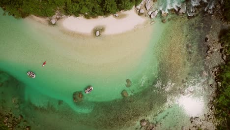 vista aérea de un grupo haciendo rafting con agua limpia y rocas en la parte inferior.