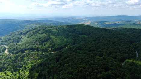 lush green hills under a clear sky. aerial view of lush green hills and distant mountains on a sunny day, showcasing nature's beauty