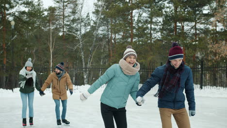 friends ice skating in winter park