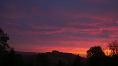 increíble puesta de sol de color rojo y naranja sobre el campo de east devon detrás de la colina de dumpdon