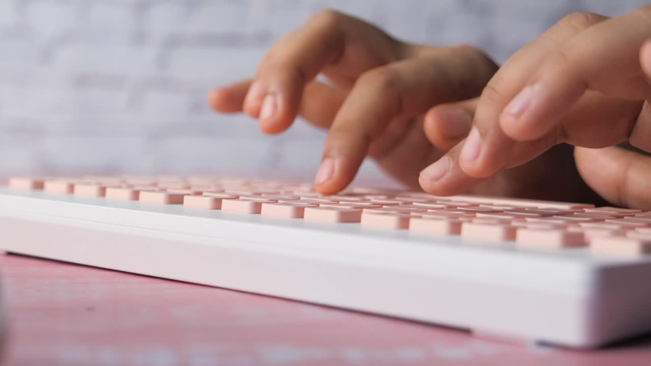mujer escribiendo en un teclado rosa