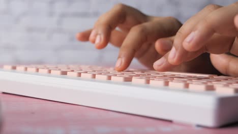 woman typing on a pink keyboard