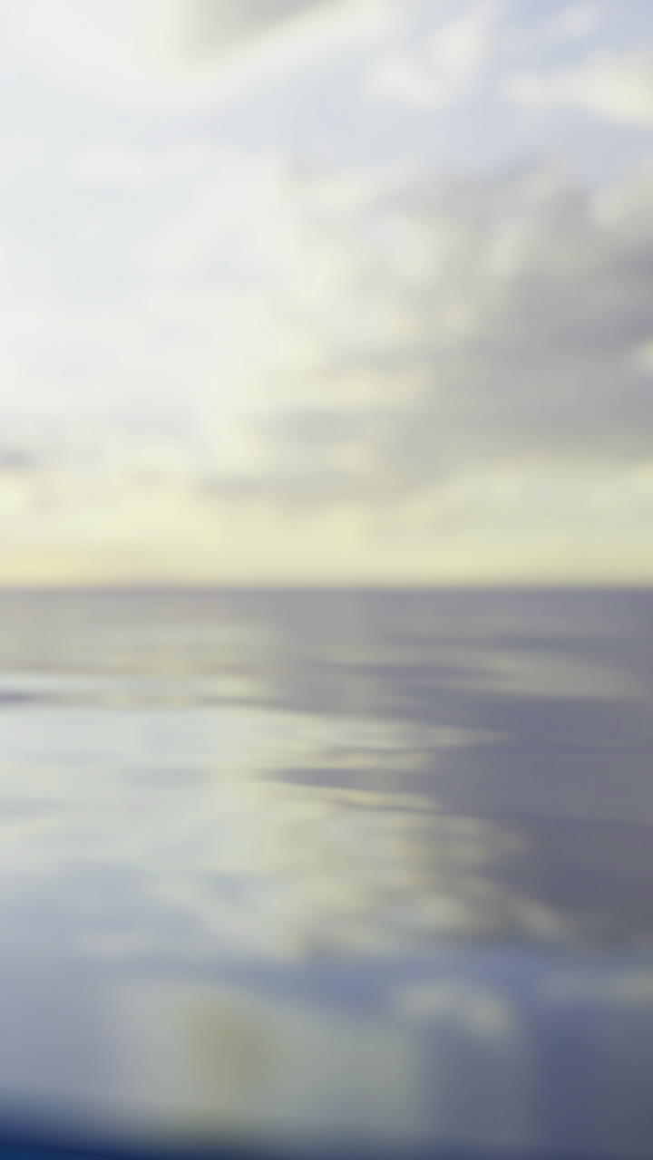 Calm water reflects clouds in the sky during sunset near the ocean shore