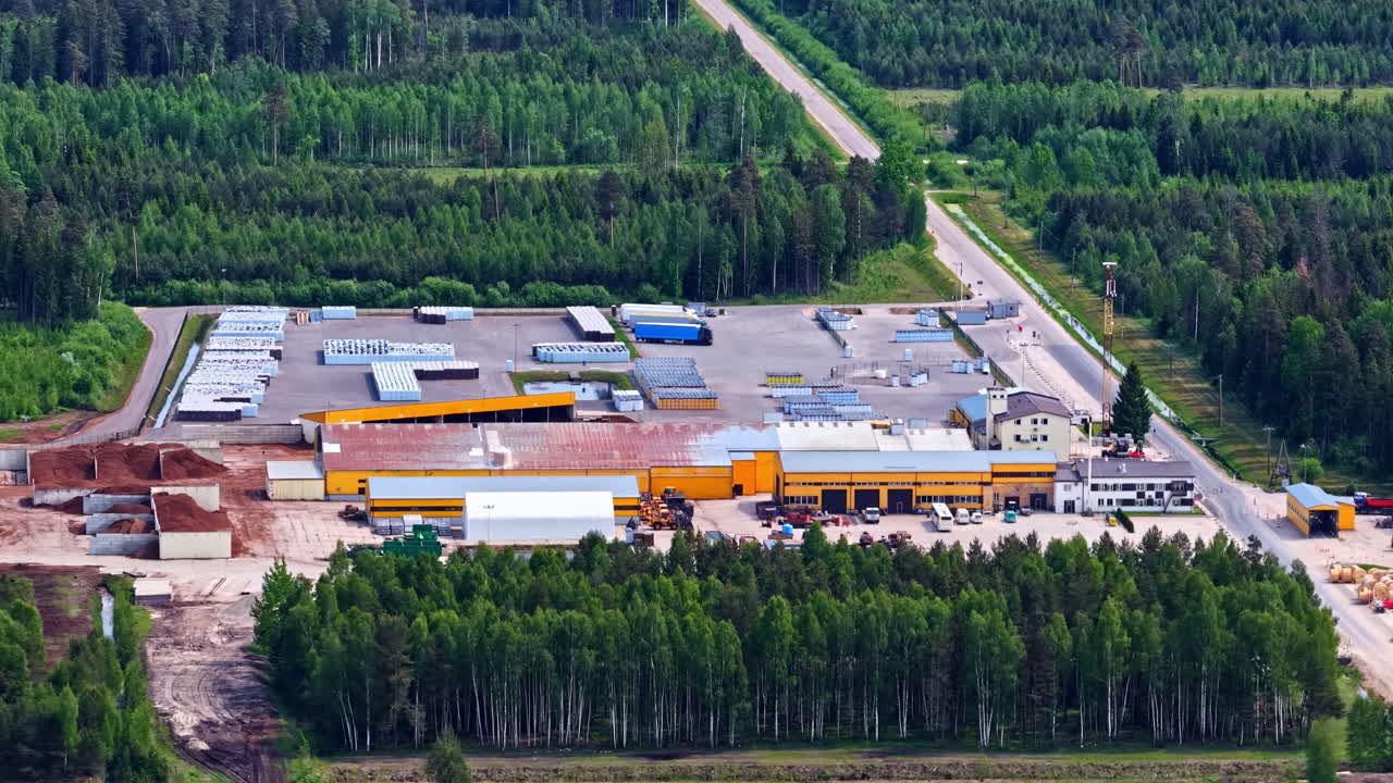 Industrial peat processing factory with storage piles surrounded by green forest