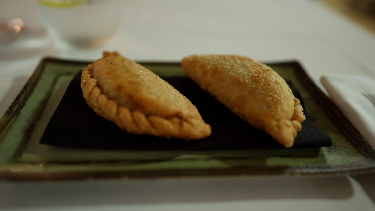Primo piano di empanadas spagnole tradizionali servite su un piatto. Spuntino di pasta dorata al forno tipico della cucina mediterranea e delle tapas.