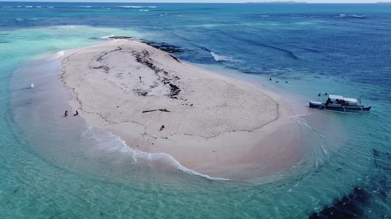 Tourists and tour boat on tiny sandbank of naked island in Siargao, Aerial
