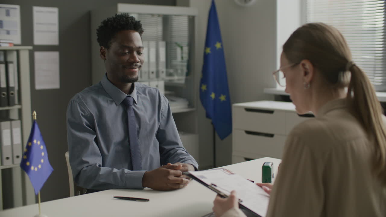 African American Man Attending Interview with Female Visa Officer at EU Embassy