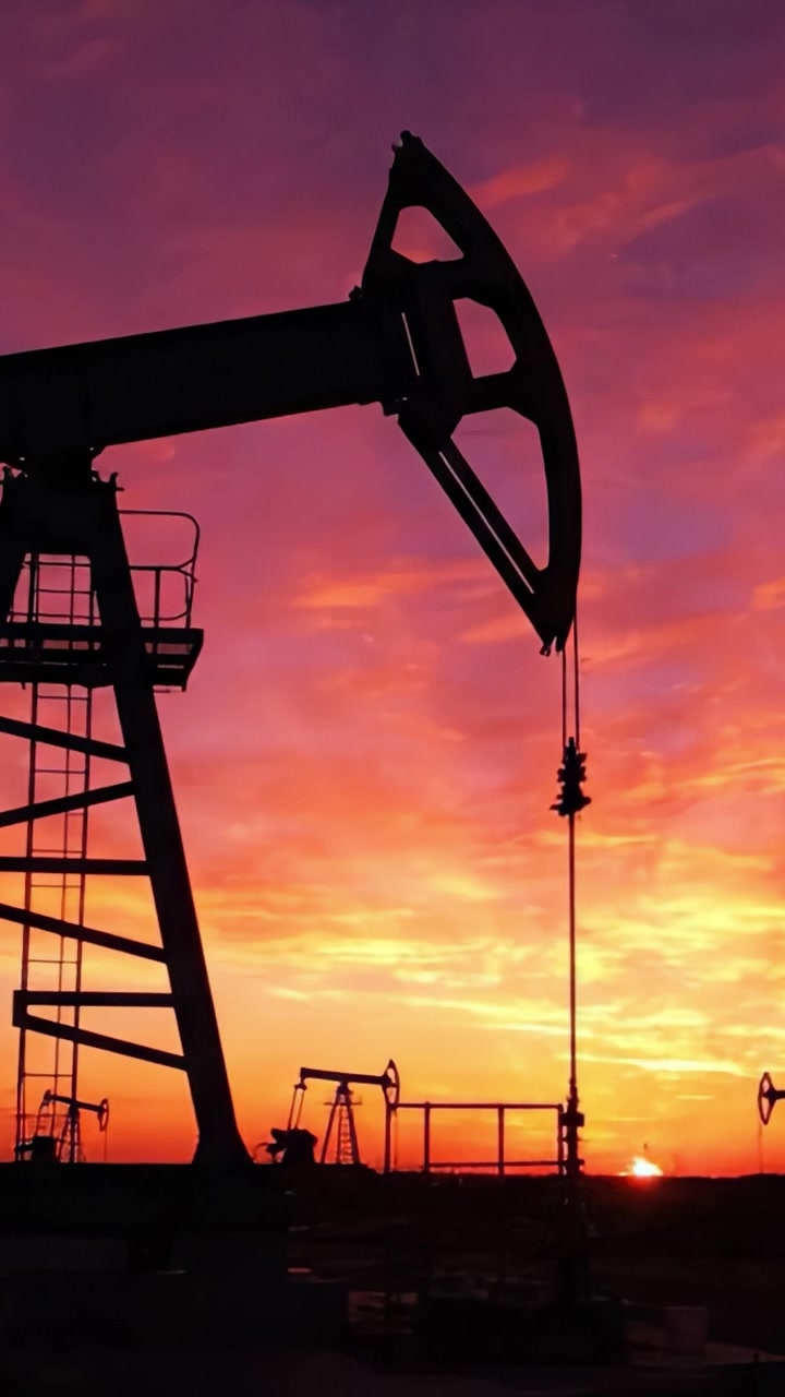 Silhouette of Oil Pump Jack Against a Vibrant Sunset Sky, Highlighting the Energy Sector's Dramatic Changes During Dusk and the End of the Day