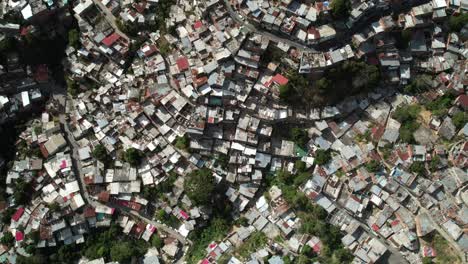 colorful rooftops in dense nazareno, petare barrio seen from aerial tilt-up shot