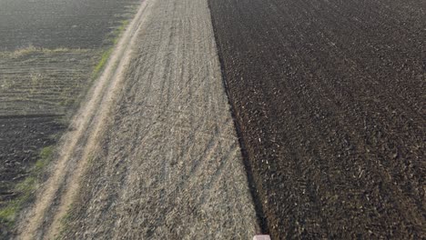 dramatic fly past with tilt up reveal of large scale farm lands being ploughed