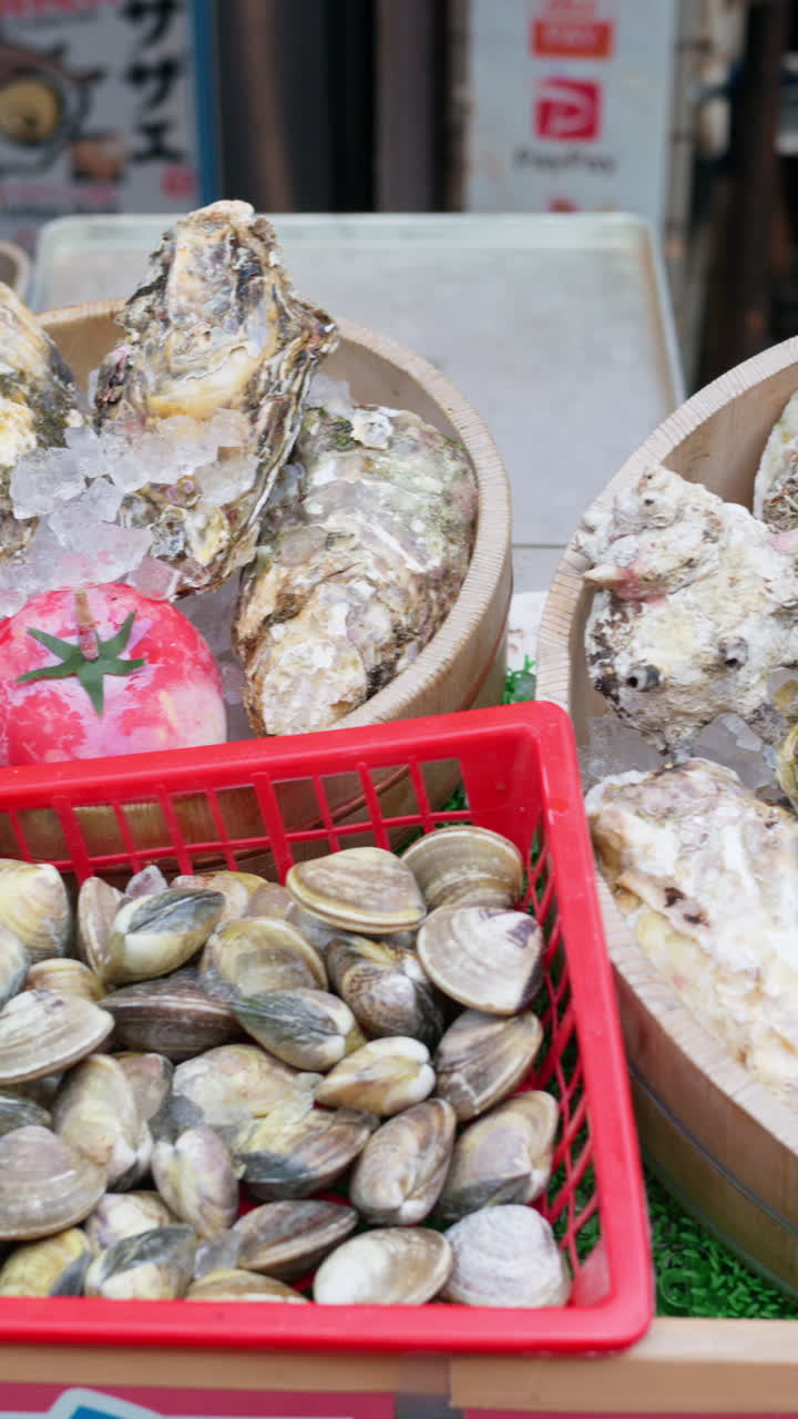 Different types of seashells on ice at the Tsukiji Fish Market in Japan. Vertical