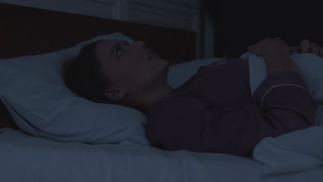 mujer experimentando una pesadilla en la cama por la noche