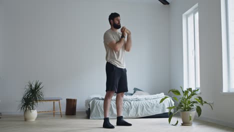 hombre haciendo un ejercicio de calentamiento en casa