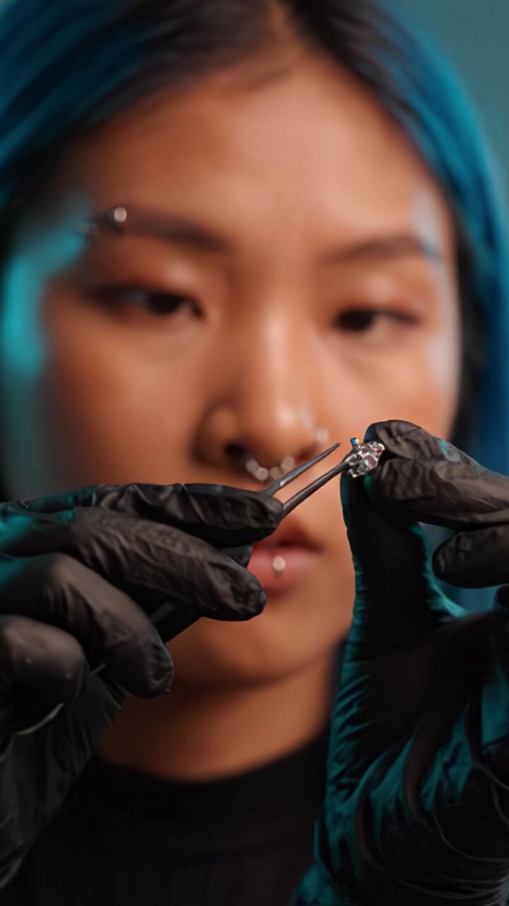 Exploring Intricate Body Piercing: Close-up of a Professional Preparing Jewelry with Precision and Care, Showcasing Skill in Body Art and Aesthetics