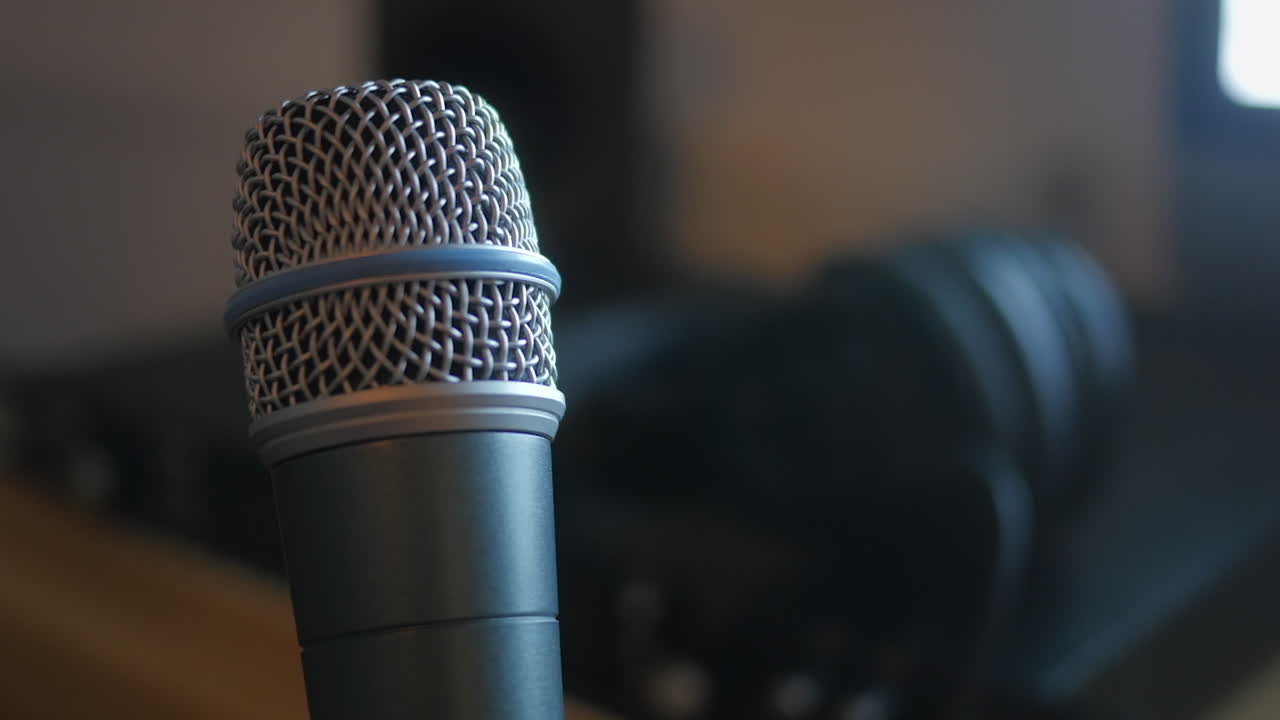 A professional dynamic microphone, rotating slowly in a home recording studio. CINEMATIC STATIC CLOSE UP SHOT.