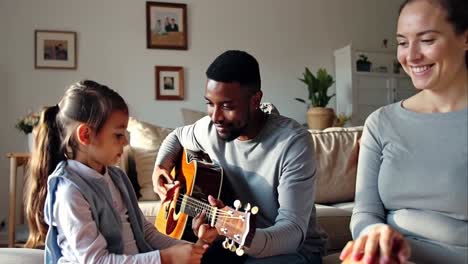 a man is teaching a young girl how to play the guitar