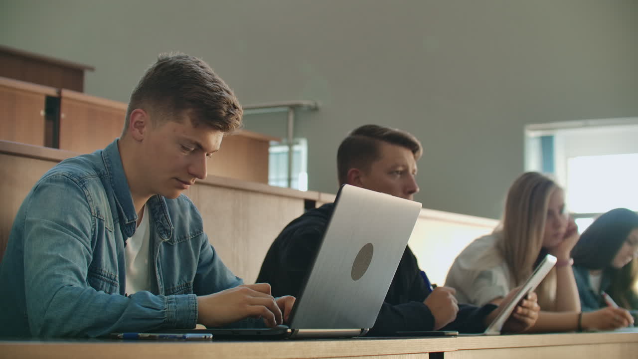 un grupo de personas en la universidad escucha una conferencia y escribe un resumen en un cuaderno detrás de un profesor universitario. estudiantes modernos