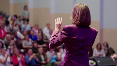 woman giving a presentation to a large audience