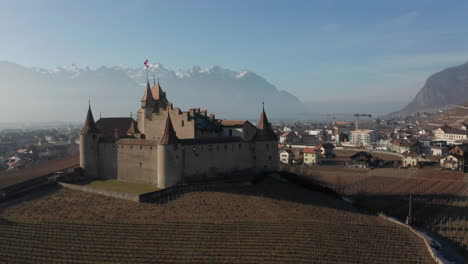 Aerial-of-beautiful-old-castle-and-revealing-the-old-town-of-Aigle-in-Switzerland