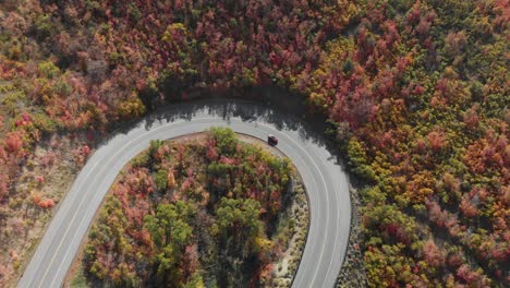 Top-down-subject-of-red-car-on-Emigration-Canyon-road-loop-during-fall-Utah,-USA