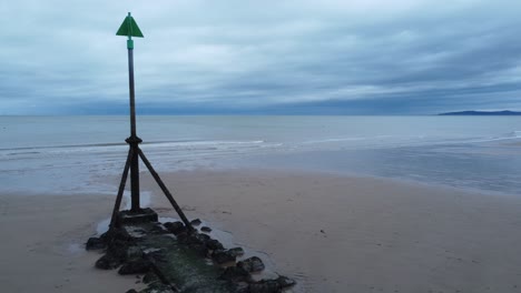 coastal tide marker aerial view low reverse reveal across moody overcast low tide seaside beach