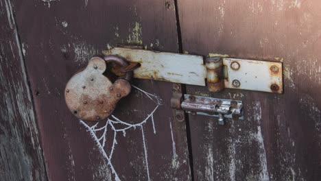 Nahaufnahme-Eines-Gefrorenen-Spinnennetzes-Auf-Einem-Vorhängeschloss