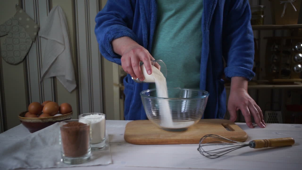 셰프 요리. 남자는 유리 그 ⁇ 에 초콜릿 케이크를 위한 재료를 추가합니다.