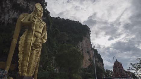 golden statue of a hindu god at batu caves, malaysia