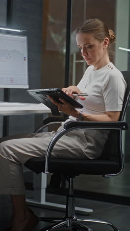 female financial analyst working on computer with multi-monitor workstation, monitoring real-time stocks and exchange market charts. successful businesswoman in financial agency office. vertical shot.