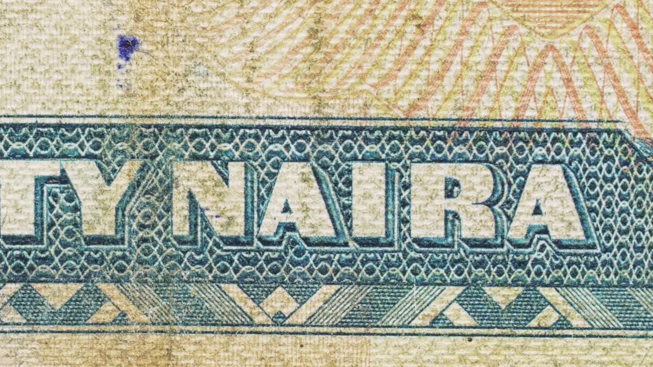 Close-up pan highlighting “Naira” lettering and security patterns on a Nigerian note