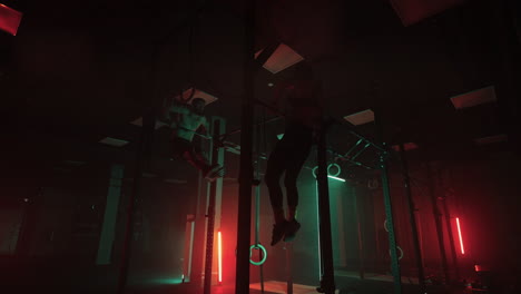 gimnasia acrobática en el club de fitness hombre y mujer están colgando de la barra y levantando el cuerpo