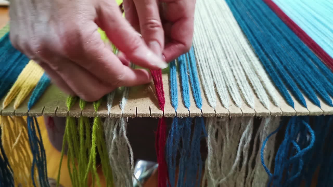 vista de cerca de un tejedor artesano tirando de hilos de hilo a través de una tabla de madera