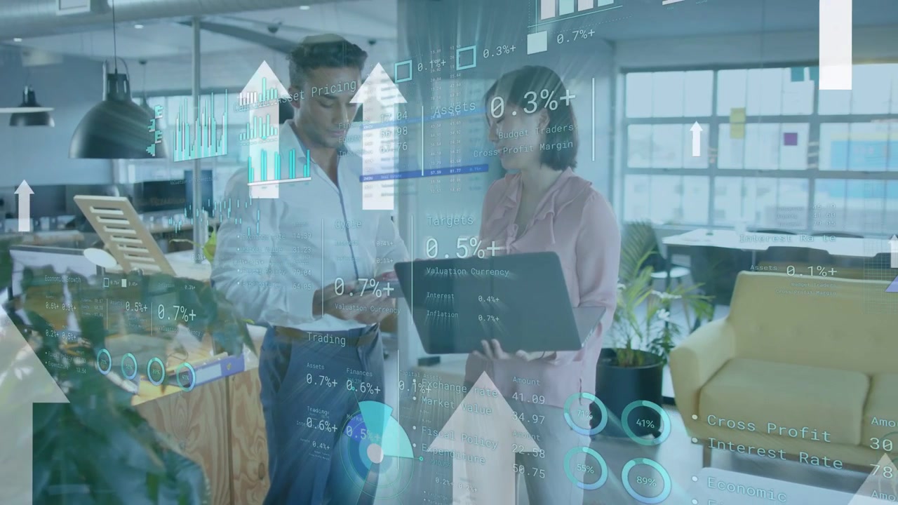 Male tapping tablet while woman holding laptop, initiating financial charts and analyzing trends