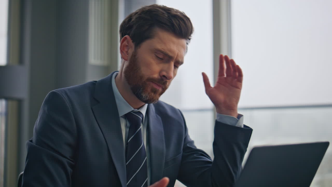 Primo piano di lavoratore accigliato che digita al laptop, impegnato nel lavoro. Uomo d'affari stanco che riflette.