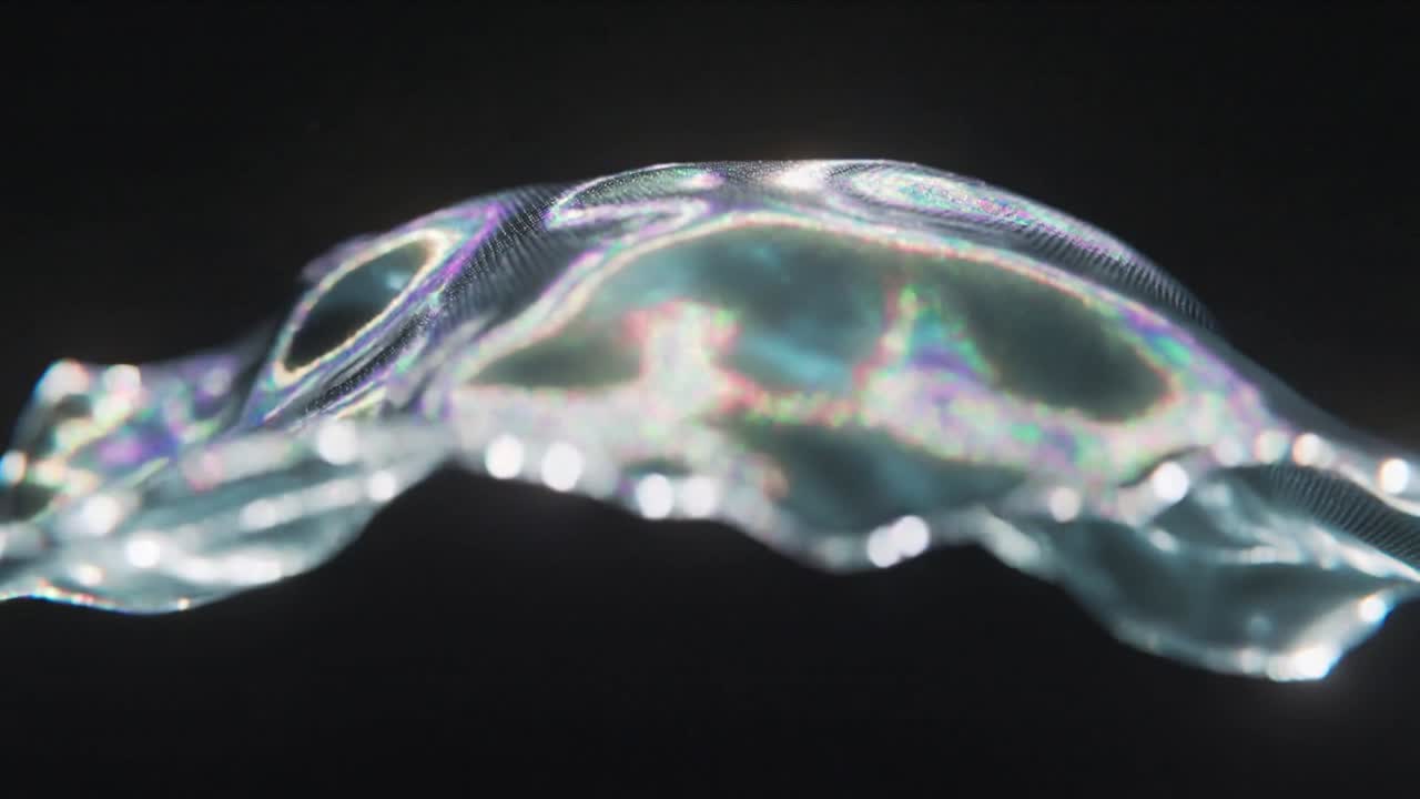 Undulating iridescent sheet reacting to light pulses in dark studio, revealing mesh and bokeh