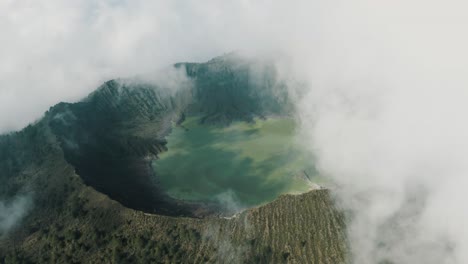 toma aérea de aves del gran volcán el chichón con nubes flotantes y lago de cráter ácido a la luz del sol, méxico