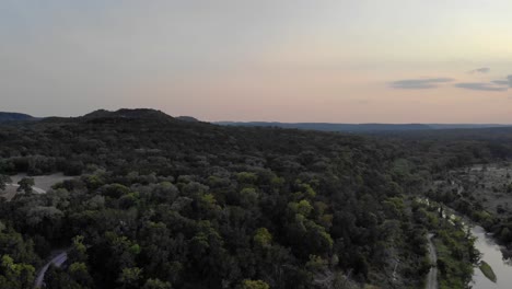 panorámica a la izquierda de la puesta del sol que muestra los campos, los árboles y el río de la región montañosa