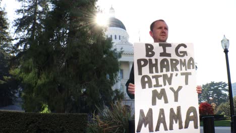 male political protester with big pharma ain't my mama sign