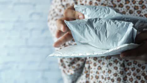 person holding crumpled light blue envelopes